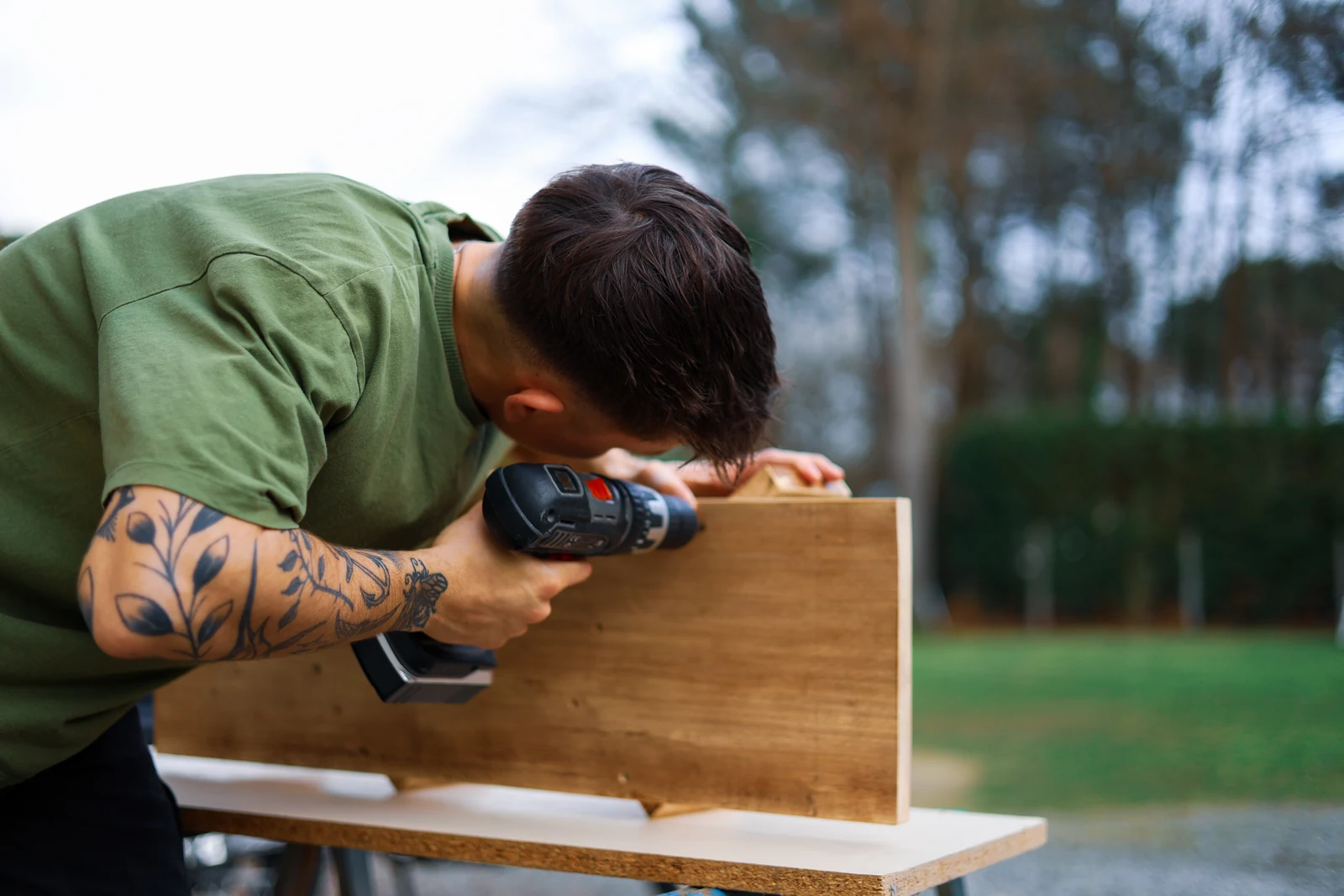 Marc-Antoine perçant une pièce de bois dans l’atelier